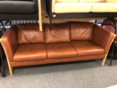A late 20th century Scandinavian wooden framed three seater brown leather settee
