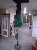 A garden parasol on circular cast iron base.