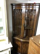 A Reprodux Regency style serpentine fronted double door corner cabinet fitted with cupboards