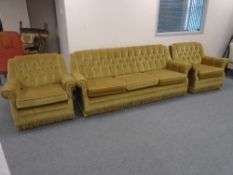 A 20th century buttoned backed three piece golden fabric suite