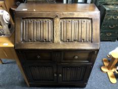 A 20th century oak linenfold bureau.