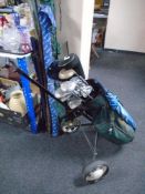 A golf trolley and golf bag containing a set of Dunlop irons and drivers.