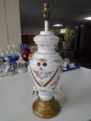 An opaque glass table lamp with floral decoration on red ground