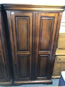 A reproduction mahogany double door wardrobe.