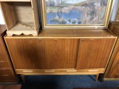 A Scandinavian teak three door high sideboard on raised legs, fitted with drawers beneath.