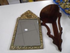 A mahogany corner wall shelf together with a brass embossed framed mirror.