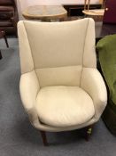 A mid century Danish armchair in cream corded fabric on teak legs