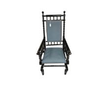 A 20th century ebonised rocking chair