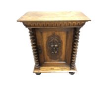 A carved oak single door cabinet on bun feet,
