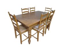 A pine farmhouse dining table with six ladder backed chairs,