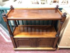 A Victorian mahogany two tier dumb waiter fitted with cupboards below,