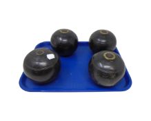 Four vintage wooden lawn bowls.