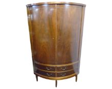 A walnut double door bowfront corner cabinet fitted with doors beneath