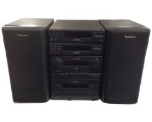 A Technics HiFi system with a pair of speakers and remote control.