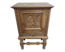 A Continental carved oak cabinet cupboard fitted with a drawer beneath.