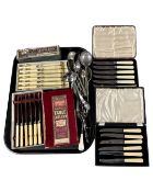A tray containing boxed and unboxed plated cutlery.
