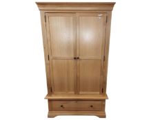 A contemporary light oak double door wardrobe fitted with a drawer.