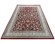 A machine made Persian design carpet on red ground, 287cm by 200cm.