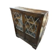 An oak side cabinet with leaded glass door.