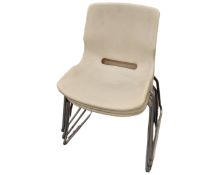 Three plastic and metal stacking chairs.