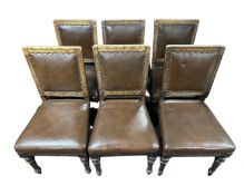 A set of six carved oak dining chairs in studded vinyl upholstery.