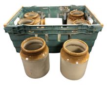 A crate containing eight stoneware storage jars.