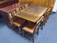 An Edwardian oak drop leaf table together with six chairs.