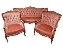 A continental carved beech three piece lounge suite comprising of a three seater settee and a pair