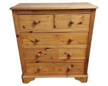 A contemporary pine chest of five drawers.