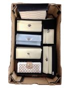 A box containing seven Wolf leather purses.