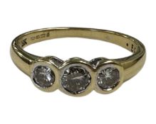 An 18ct gold three stone diamond set ring, the stated total diamond weight 0.50 carat, size N.