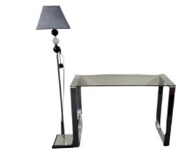 A contemporary glass topped console table on metal legs together with a further contemporary