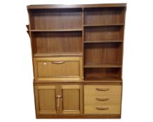 A 20th century teak cocktail bookcase fitted with cupboards and drawers