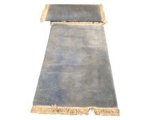 Two fringed Chinese rugs on blue ground, 163cm by 78cm and 206cm by 125cm.