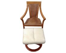 A contemporary leather upholstered armchair together with a cream leather footstool