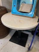 A circular faux-marble bistro table with cast iron pedestal.