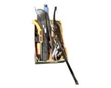 A box containing a bow with arrows, a BB pellet pump action shotgun, military pouches.