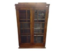 A 20th century oak glass door bookcase