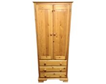 A pine double door narrow wardrobe fitted with three drawers