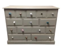 A painted pine thirteen drawer block chest with odd handles