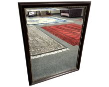 A contemporary bevelled mirror in a mahogany effect frame, 69cm by 89cm.