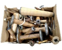 A box containing a collection of vintage wooden bobbins.