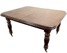 A mahogany extending dining table on brass castors together with two leaves.