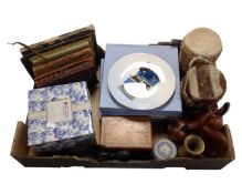 A box containing boxed Wedgwood plates depicting busses, tribal hand drums, carved wooden figures,