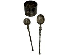 A silver napkin ring and two spoons.