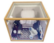 A doll's house diorama of a Victorian bedroom, in display case.