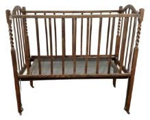 An Edwardian oak barleytwist cot.
