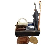 A box containing vintage handbags and umbrellas.