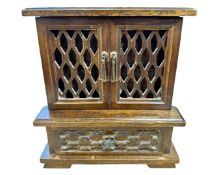 A wooden musical jewellery box modelled as a fretwork cabinet with internal drawers,