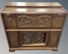 A 20th century heavily carved oak gramophone cabinet.